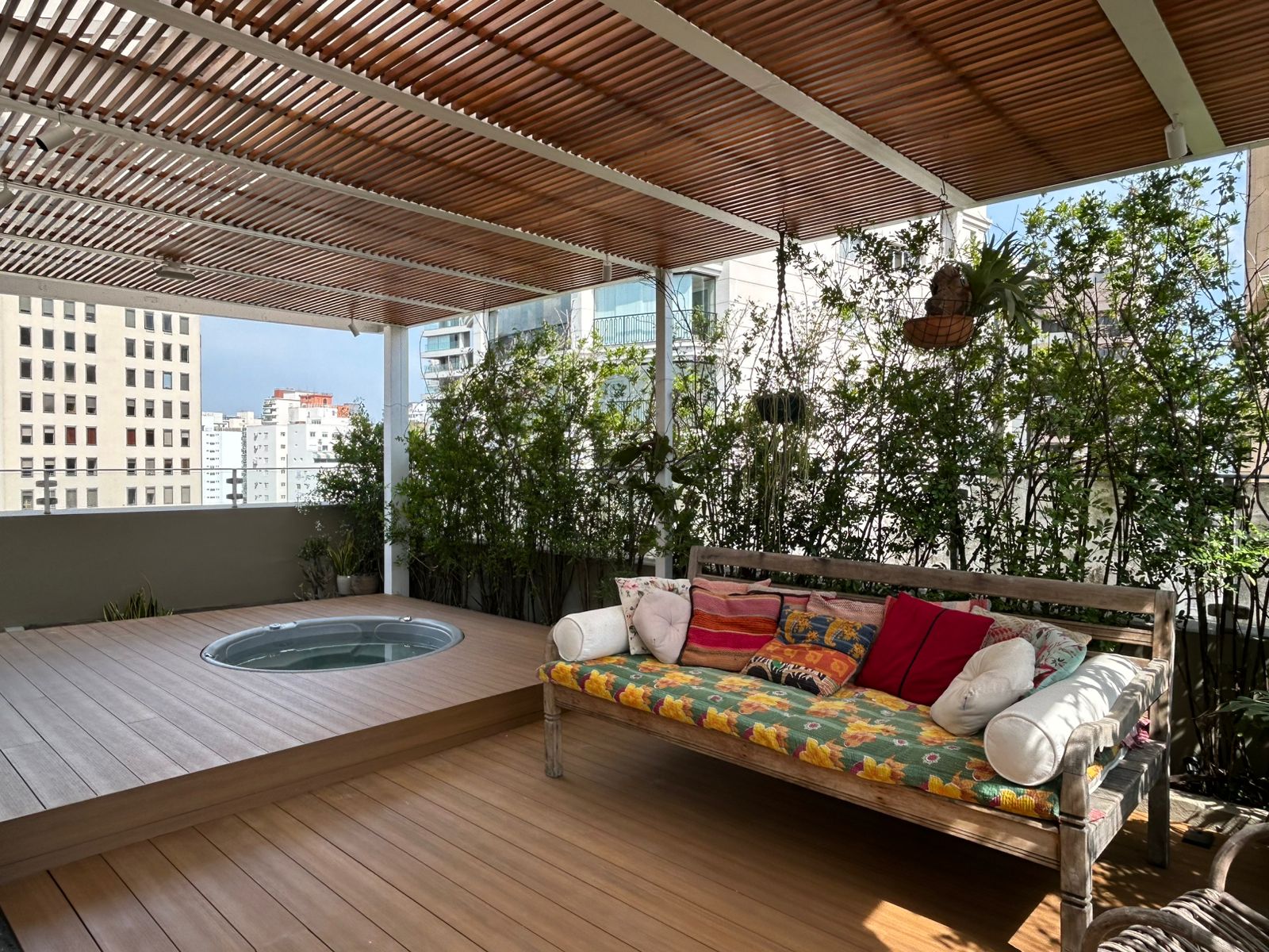 Área externa com deck em madeira e cobertura ripada