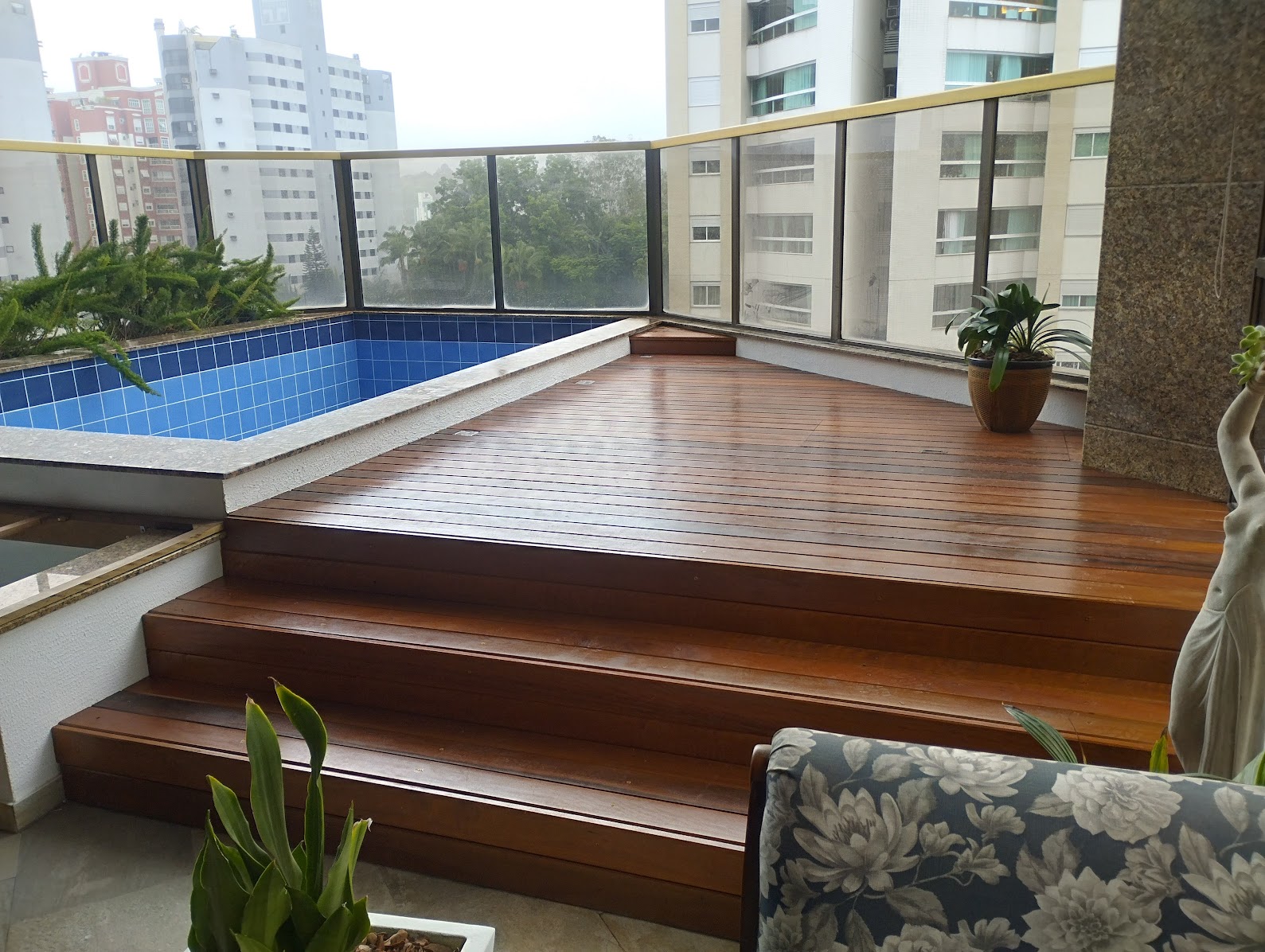 Deck de madeira maciça em área de piscina de apartamento